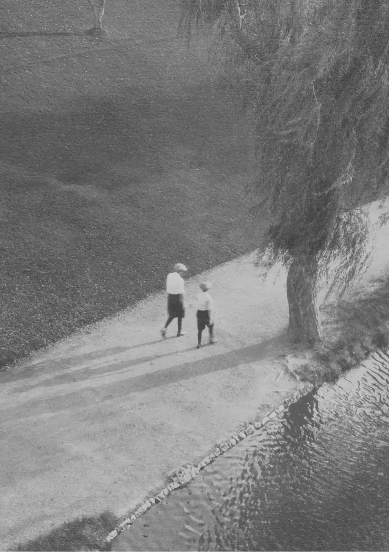 Black and white photo focusing on a woman and a child from afar.